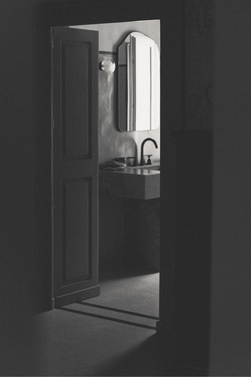 Dark moody photo of a luxurious bathroom at night.