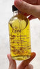 Video of UMM Skincare pre shower body oil with gold flakes floating in the luxurious oil.