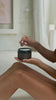 Woman applying rich creamy body cream to her legs, leaving her skin shiny and smooth.